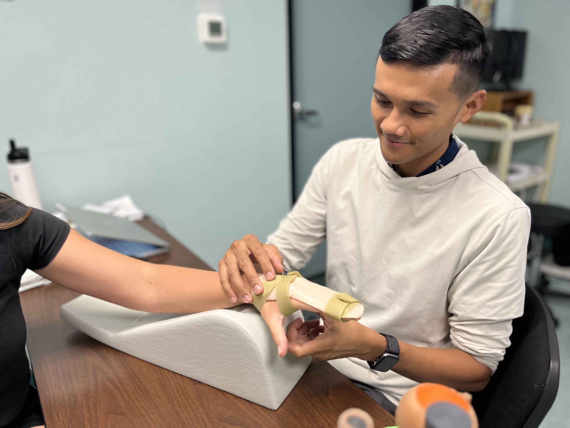 image of physical therapist performing exercises on a patients hand